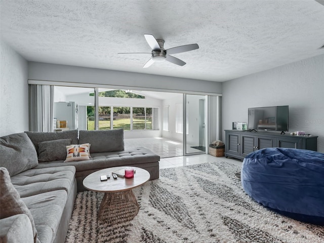 tiled living area with ceiling fan, a textured ceiling, and a textured wall