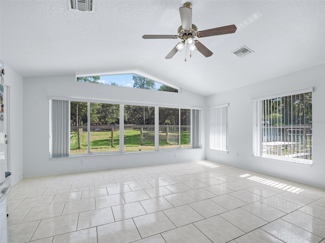 tiled spare room with visible vents, vaulted ceiling, and a textured ceiling