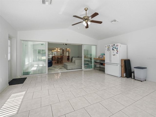 interior space featuring light tile patterned floors, lofted ceiling, visible vents, and ceiling fan with notable chandelier