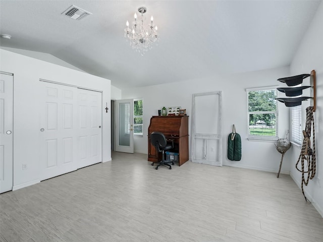 office space with a notable chandelier, light wood finished floors, lofted ceiling, visible vents, and baseboards