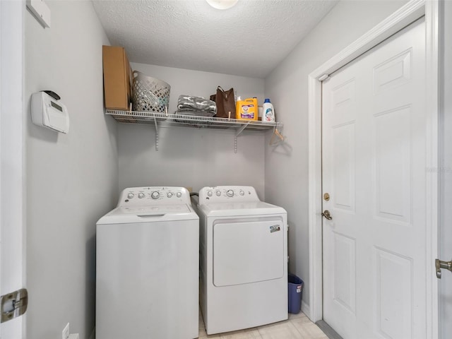 laundry area featuring laundry area, washing machine and dryer, and a textured ceiling