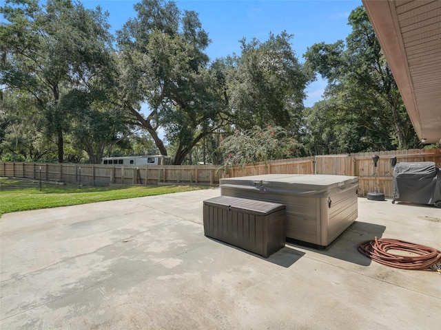 view of patio with a hot tub, grilling area, and a fenced backyard