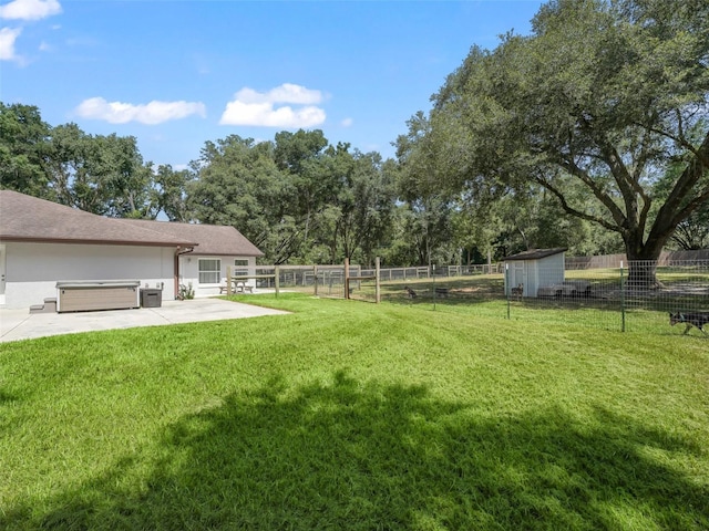 view of yard featuring a patio, a storage unit, a hot tub, a fenced backyard, and an outdoor structure