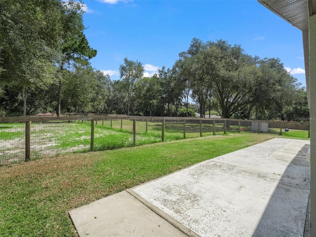 view of yard with a rural view, fence, and a patio