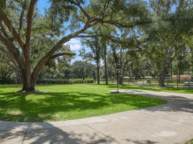 view of community with fence and a lawn