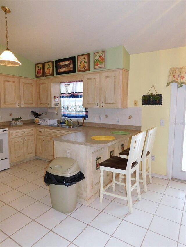 kitchen with range, tasteful backsplash, light brown cabinets, light tile patterned floors, and hanging light fixtures