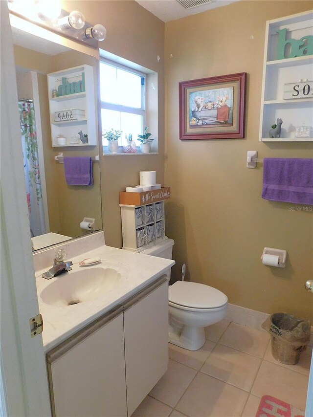 bathroom featuring vanity, tile patterned flooring, and toilet