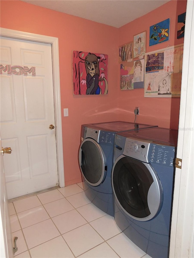 washroom with light tile patterned flooring and washer and dryer