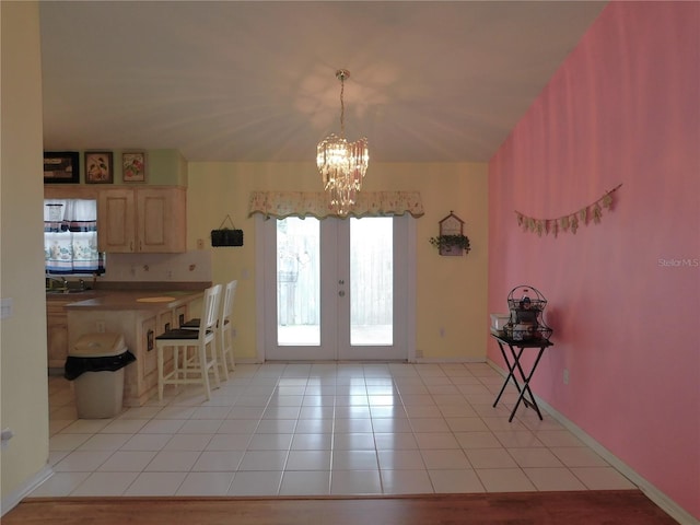 interior space with light tile patterned flooring, french doors, a notable chandelier, and decorative light fixtures