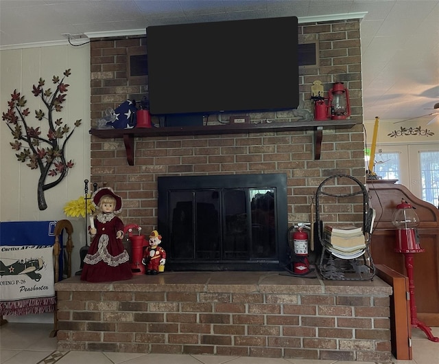 tiled living room with a brick fireplace, brick wall, and french doors