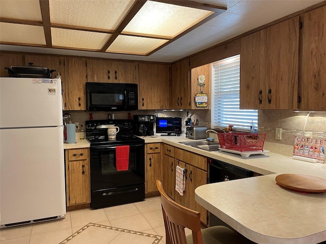 kitchen featuring sink, black appliances, backsplash, and light tile patterned floors