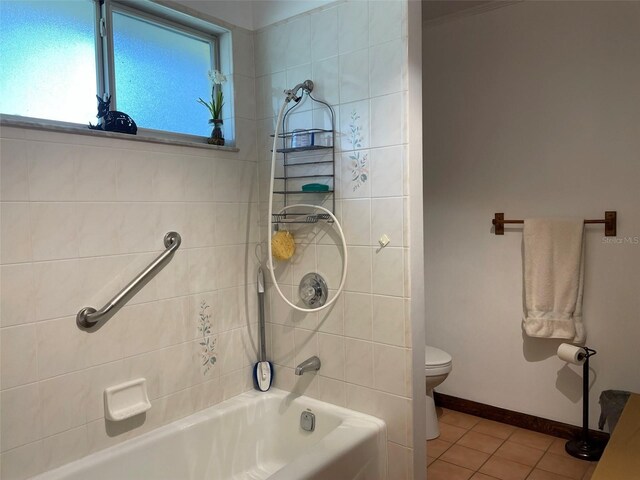 bathroom featuring tile patterned floors, tiled shower / bath combo, and toilet