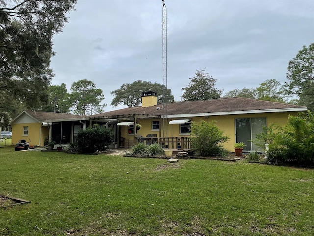 rear view of house featuring a yard