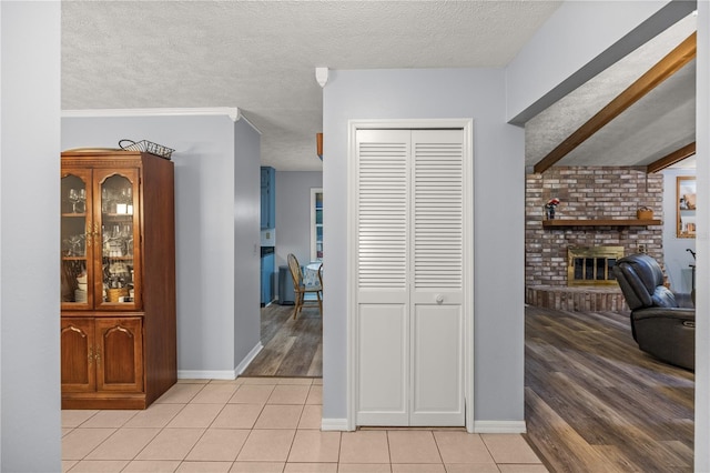 corridor featuring light hardwood / wood-style floors and a textured ceiling