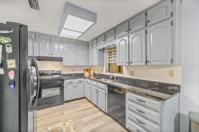 kitchen featuring dishwasher, light hardwood / wood-style floors, sink, stainless steel fridge, and electric range oven