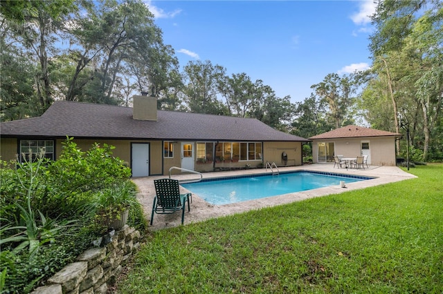 view of pool with a lawn and a patio