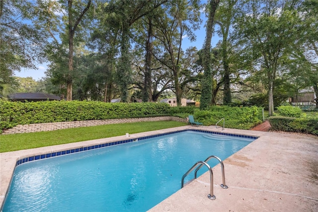 view of pool with a lawn and a patio