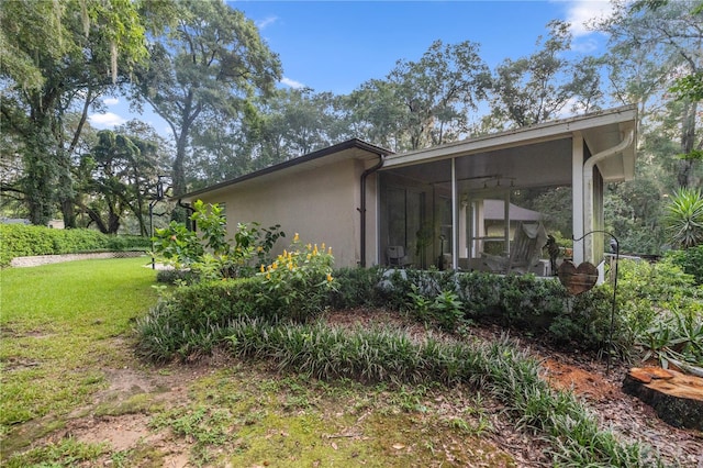 rear view of property with a lawn and a sunroom