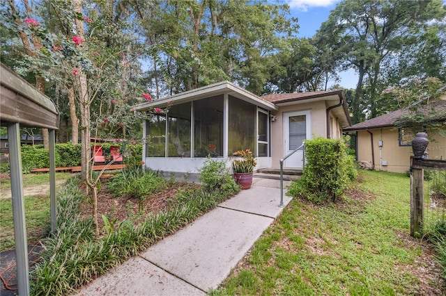 view of front of home with a sunroom and a front lawn