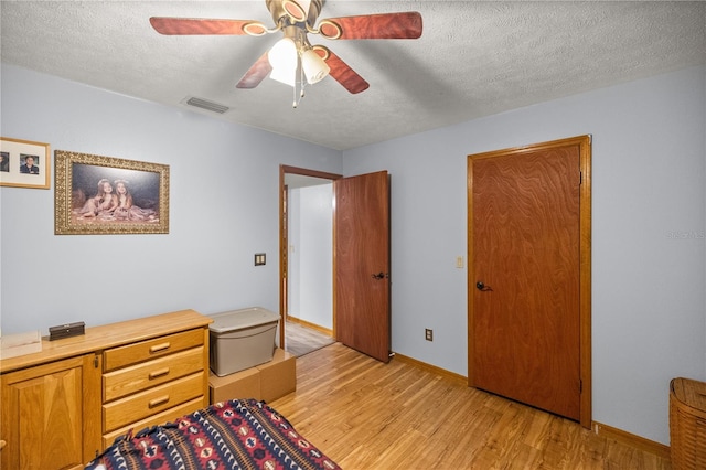 bedroom featuring a textured ceiling, ceiling fan, and light hardwood / wood-style floors