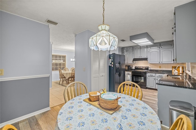 dining room with a textured ceiling, light hardwood / wood-style flooring, and sink