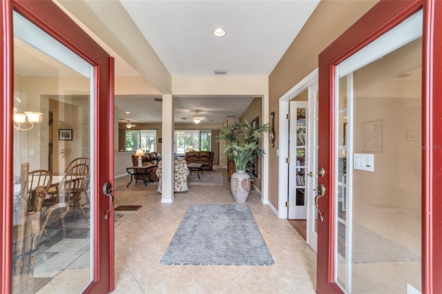 tiled foyer entrance with ceiling fan and french doors