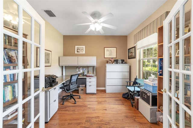 office area with built in desk, ceiling fan, and light hardwood / wood-style floors