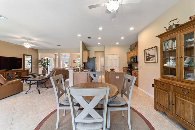 dining room with ceiling fan, sink, and light tile patterned floors