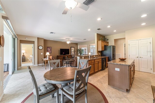 dining room with ceiling fan, sink, and light tile patterned floors