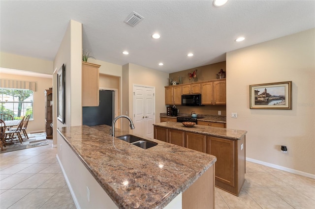 kitchen with stone counters, sink, black appliances, kitchen peninsula, and a textured ceiling