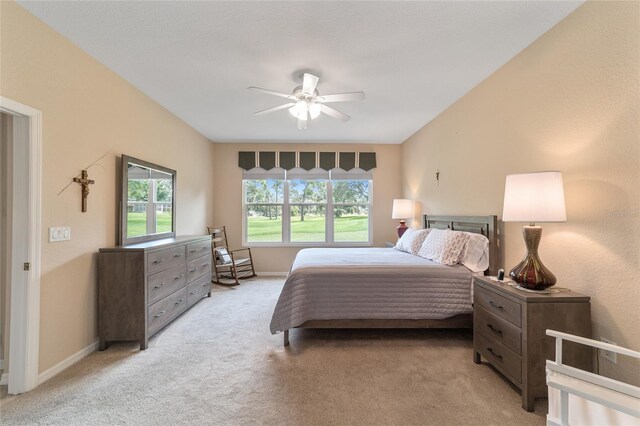 bedroom with light colored carpet, ceiling fan, and multiple windows