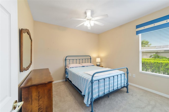 bedroom featuring multiple windows, light colored carpet, and ceiling fan