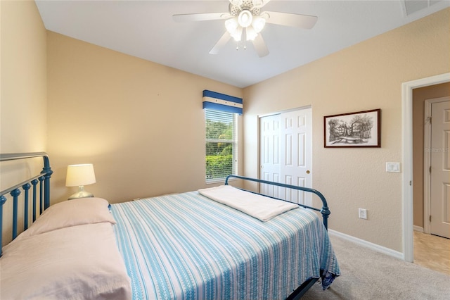 bedroom featuring a closet, light colored carpet, and ceiling fan