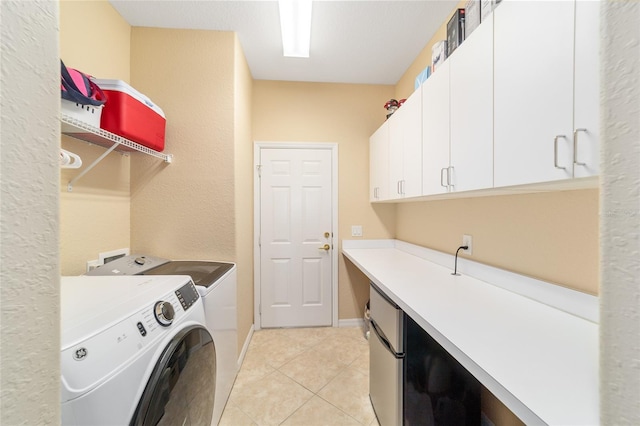 laundry room with washer and dryer, cabinets, and light tile patterned floors