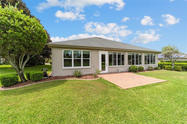 rear view of property featuring a yard and a patio