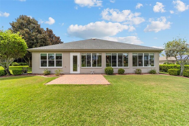 back of house with a lawn and a patio