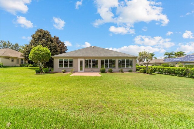 rear view of property with a lawn and a patio