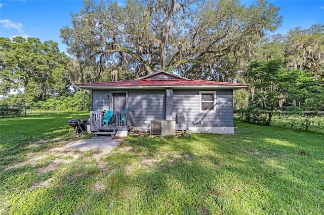 rear view of property featuring a lawn