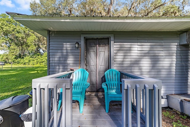 entrance to property featuring a yard and a wooden deck