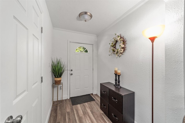 foyer entrance with ornamental molding and hardwood / wood-style floors