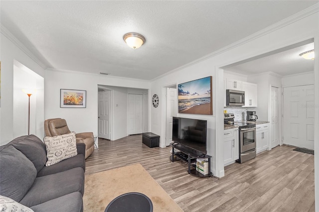 living room featuring a textured ceiling, light hardwood / wood-style floors, and ornamental molding