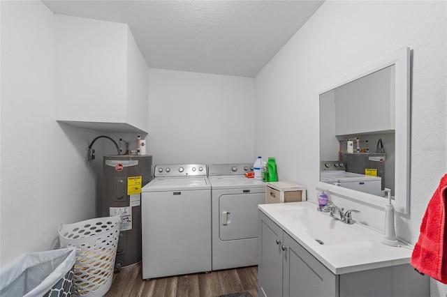 washroom featuring cabinets, electric water heater, washer and dryer, dark hardwood / wood-style floors, and sink