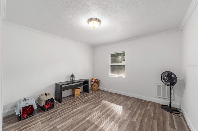 miscellaneous room with wood-type flooring, a textured ceiling, and crown molding