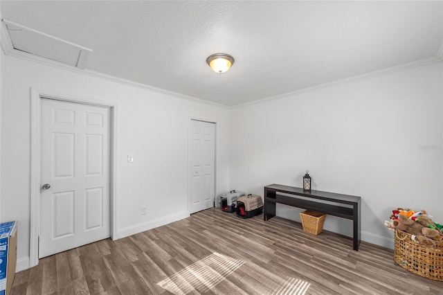 miscellaneous room with hardwood / wood-style flooring, a textured ceiling, and crown molding