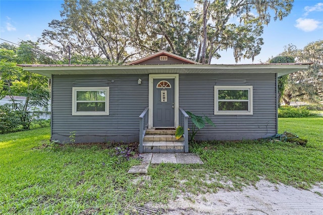 bungalow-style home with a front lawn