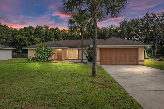 ranch-style house with a garage and a yard