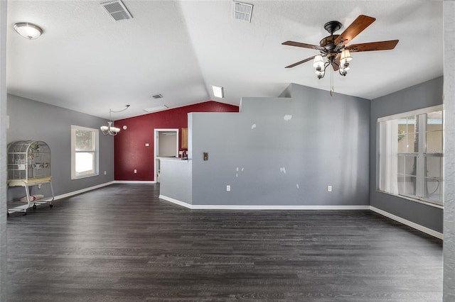 unfurnished living room featuring a textured ceiling, dark hardwood / wood-style flooring, lofted ceiling, and ceiling fan with notable chandelier