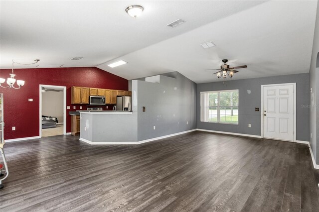 unfurnished living room featuring ceiling fan with notable chandelier, vaulted ceiling, and dark hardwood / wood-style flooring