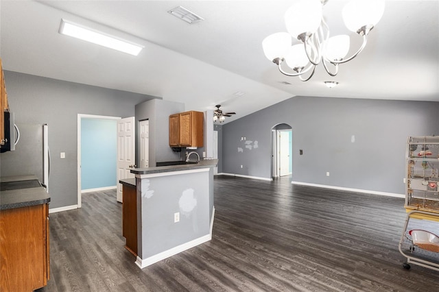 kitchen with hanging light fixtures, ceiling fan with notable chandelier, dark hardwood / wood-style floors, lofted ceiling, and kitchen peninsula