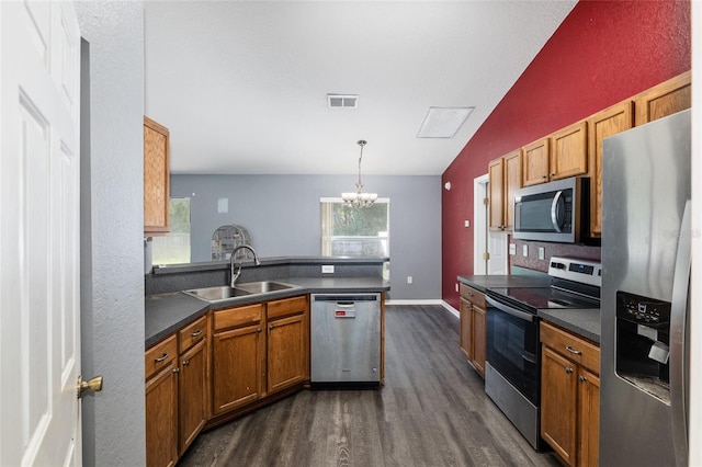 kitchen with lofted ceiling, kitchen peninsula, dark hardwood / wood-style flooring, appliances with stainless steel finishes, and sink